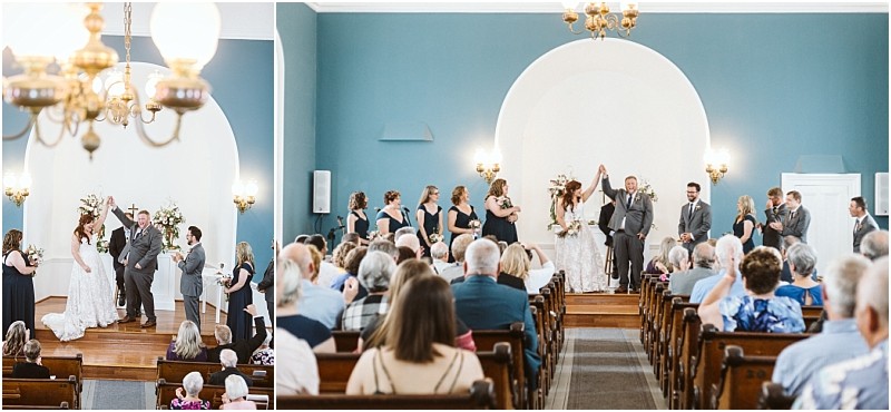 Premier snohomish & seattle wedding photographer | gsquared weddings photography a snohomish wedding ceremony takes place in a bright blue walled chapel The bride and groom stand at the altar with their wedding party raising joined hands as guests watch from pews | serving snohomish seattle                   & beyond