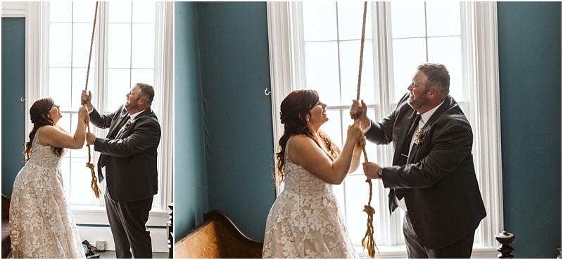 Premier snohomish & seattle wedding photographer | gsquared weddings photography a smiling bride and groom stand by tall windows in a teal room pulling a large rope togetherpossibly ringing a bellduring their snohomish wedding The bride wears a white lace dress and the groom dons a gray suit | serving snohomish seattle                   & beyond