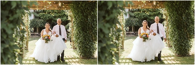 Premier snohomish & seattle wedding photographer | gsquared weddings photography a bride in a white gown holding a colorful bouquet walks arm in arm with a man in a light shirt and tie under a vine covered arbor at an outdoor snohomish wedding Both are smiling surrounded by lush greenery | serving snohomish seattle                   & beyond