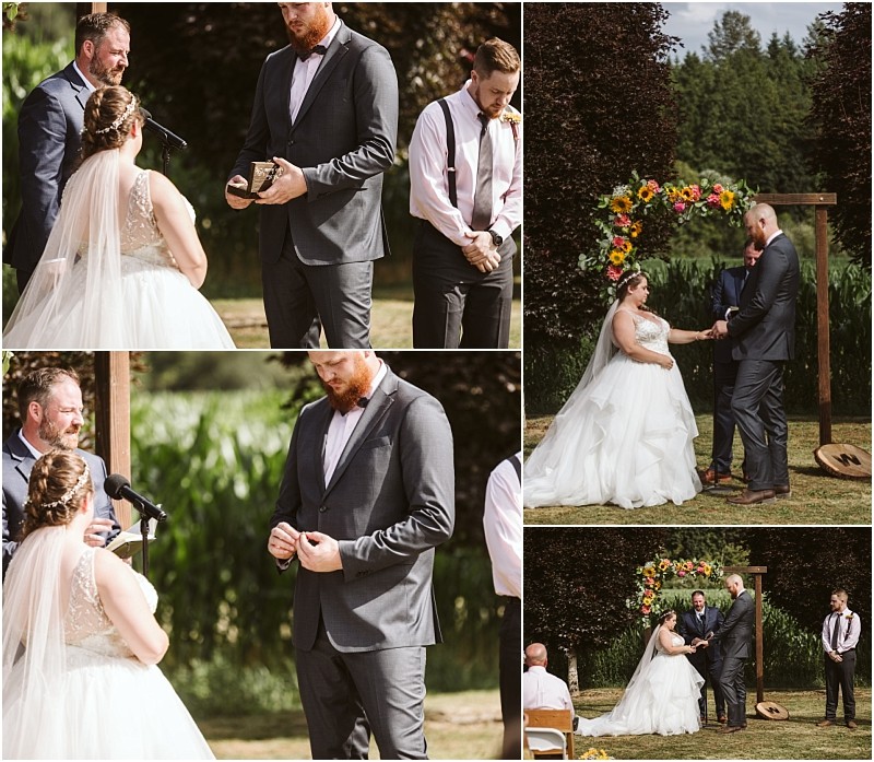 Premier snohomish & seattle wedding photographer | gsquared weddings photography a bride and groom exchange rings and vows outdoors beneath a floral arch at a snohomish seattle wedding with an officiant and groomsman beside them Sunlight filters through the trees as the bride in her white gown faces the groom in his gray suit | serving snohomish seattle                   & beyond