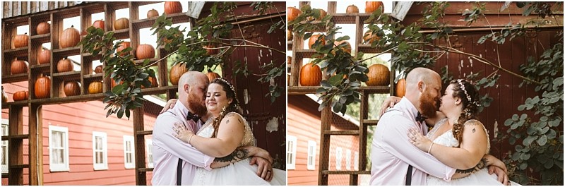 Premier snohomish & seattle wedding photographer | gsquared weddings photography a couple dressed in wedding attire embraces and kisses under a rustic wooden structure decorated with pumpkins capturing a charming snohomish wedding moment with a red building in the background | serving snohomish seattle                   & beyond
