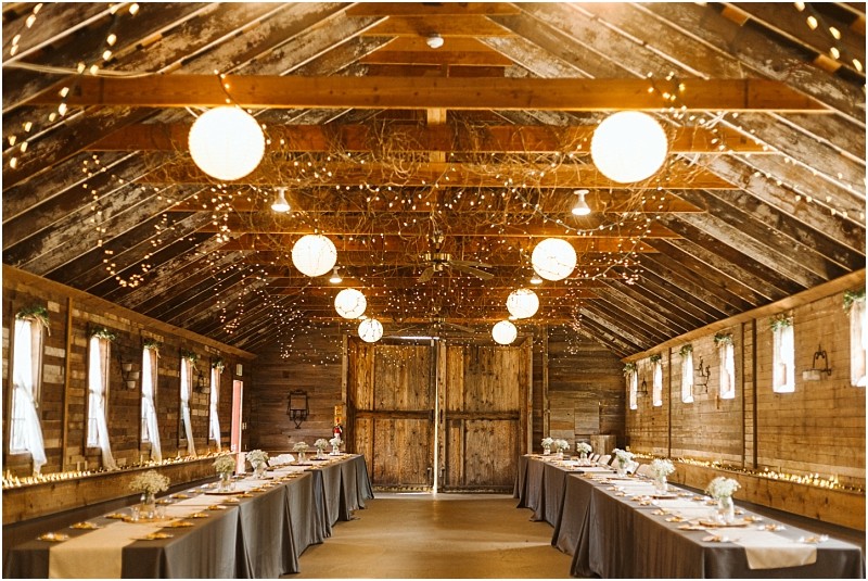 Premier snohomish & seattle wedding photographer | gsquared weddings photography a rustic barn interior in snohomish decorated for a seattle wedding or engagement glows with string lights and round lanterns Long tables with gray tablecloths and simple floral centerpieces line both sides of the room | serving snohomish seattle                   & beyond
