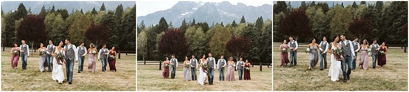 Premier snohomish & seattle wedding photographer | gsquared weddings photography a snohomish wedding party walks across a grassy field with trees and mountains in the background The group is dressed in formal attire including suits and dresses and some hold bouquets | serving snohomish seattle                   & beyond