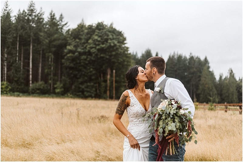 Premier snohomish & seattle wedding photographer | gsquared weddings photography a bride and groom share a romantic kiss in a field of tall grass near snohomish Surrounded by trees the bride in a white lace gown and bouquet and the groom in vest and tie capture classic seattle wedding engagement charm | serving snohomish seattle                   & beyond