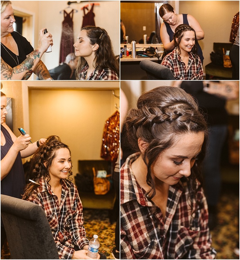 Premier snohomish & seattle wedding photographer | gsquared weddings photography a young woman in a plaid shirt gets her hair styled and makeup applied by two stylists She smiles and looks relaxed in a cozy room with dresses hanging in the background preparing for her snohomish wedding or seattle engagement | serving snohomish seattle                   & beyond
