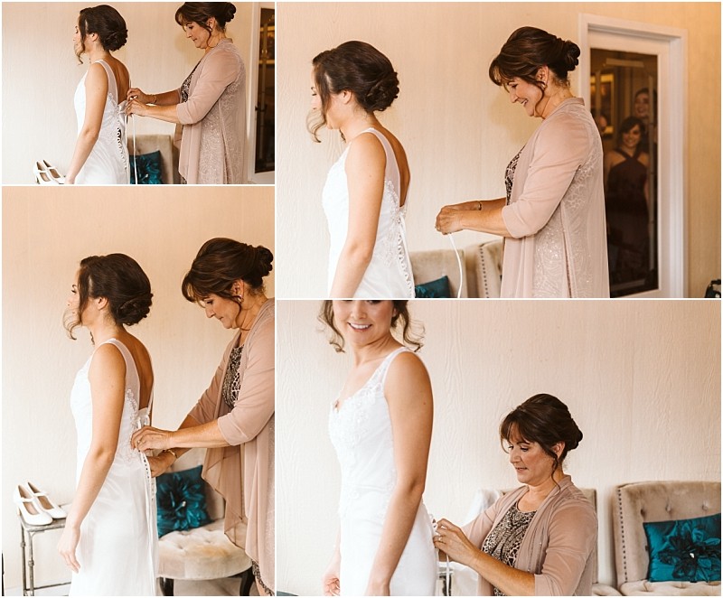 Premier snohomish & seattle wedding photographer | gsquared weddings photography in a softly lit room near snohomish a woman helps a bride button up her wedding dress as they both smile with happiness Other women in the background watch and share in the joy of this seattle wedding moment | serving snohomish seattle                   & beyond