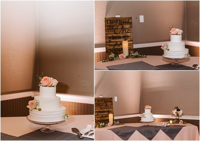 Premier snohomish & seattle wedding photographer | gsquared weddings photography a three tier white wedding cake with pink roses on top sits on a glass stand at a snohomish seattle wedding Behind it is a wooden sign candle and floral decorations creating the perfect engagement celebration scene | serving snohomish seattle                   & beyond