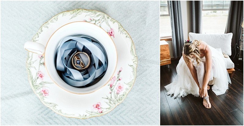 Premier snohomish & seattle wedding photographer | gsquared weddings photography a gold ring on blue ribbon inside a floral teacup sits on pale fabric Nearby a bride in a white dress bends to fasten her shoea bright moment from a snohomish seattle wedding with elegant wood floors | serving snohomish seattle                   & beyond