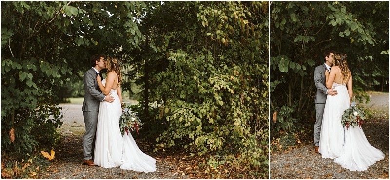 Premier snohomish & seattle wedding photographer | gsquared weddings photography a bride and groom share an embrace and kiss under lush green trees on a gravel path celebrating their snohomish wedding The bride wears a white dress with a bouquet the groom is dressed in a gray suit | serving snohomish seattle                   & beyond