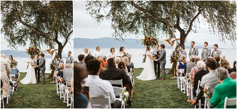 Premier snohomish & seattle wedding photographer | gsquared weddings photography an outdoor snohomish wedding ceremony by the water the bride and groom stand under a floral arch with their bridal party while guests watch from white chairs on the grass Trees and mountains frame this stunning seattle engagement setting | serving snohomish seattle                   & beyond
