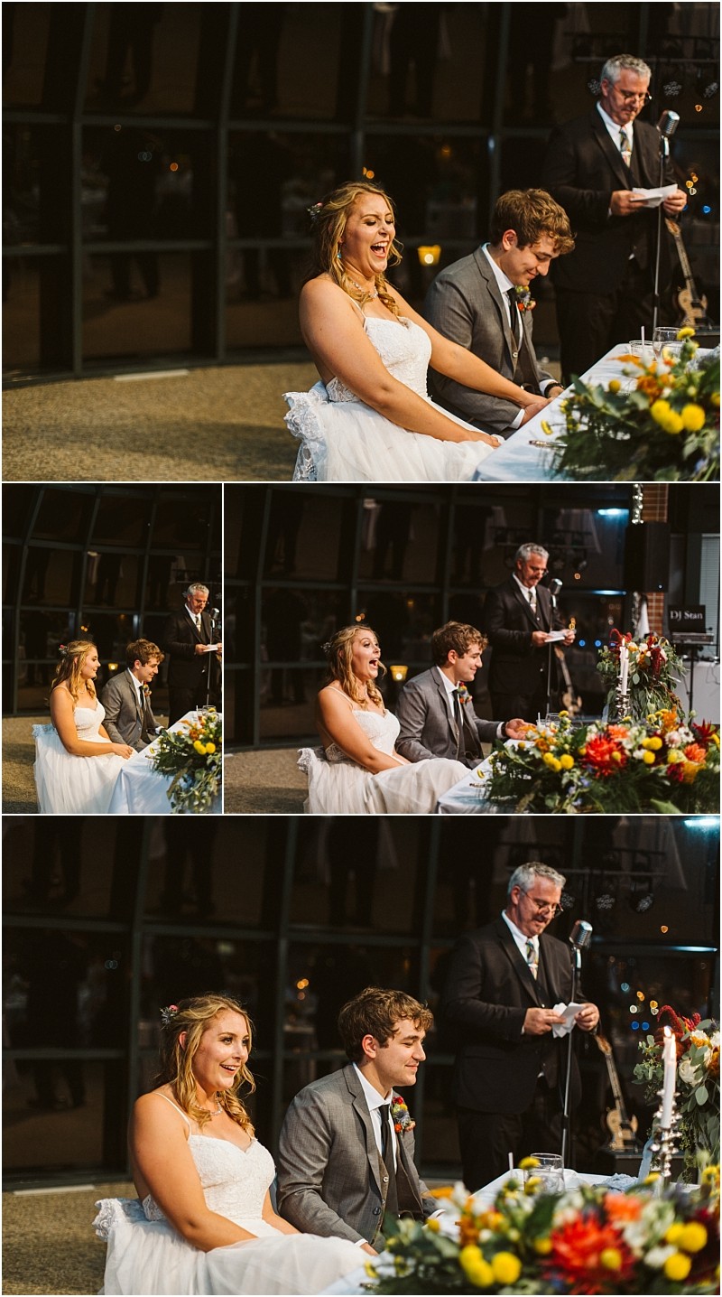 Premier snohomish & seattle wedding photographer | gsquared weddings photography a bride and groom sit smiling at a decorated table during their snohomish wedding reception while an older man stands behind them speaking into a microphone The mood is joyful and the room is warmly lit | serving snohomish seattle                   & beyond