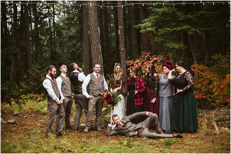 Premier snohomish & seattle wedding photographer | gsquared weddings photography a wedding party poses in a snohomish forest The bride holds a bouquet and stands with bridesmaids and groomsmen One man lies playfully in front as the rest smile and laugh capturing the joy of a seattle wedding among colorful autumn trees | serving snohomish seattle                   & beyond