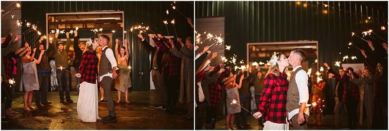 Premier snohomish & seattle wedding photographer | gsquared weddings photography a bride in a white dress and red plaid jacket stands with her groom as guests with sparklers celebrate their snohomish wedding outside a barn at night capturing the magic of a seattle engagement celebration | serving snohomish seattle                   & beyond