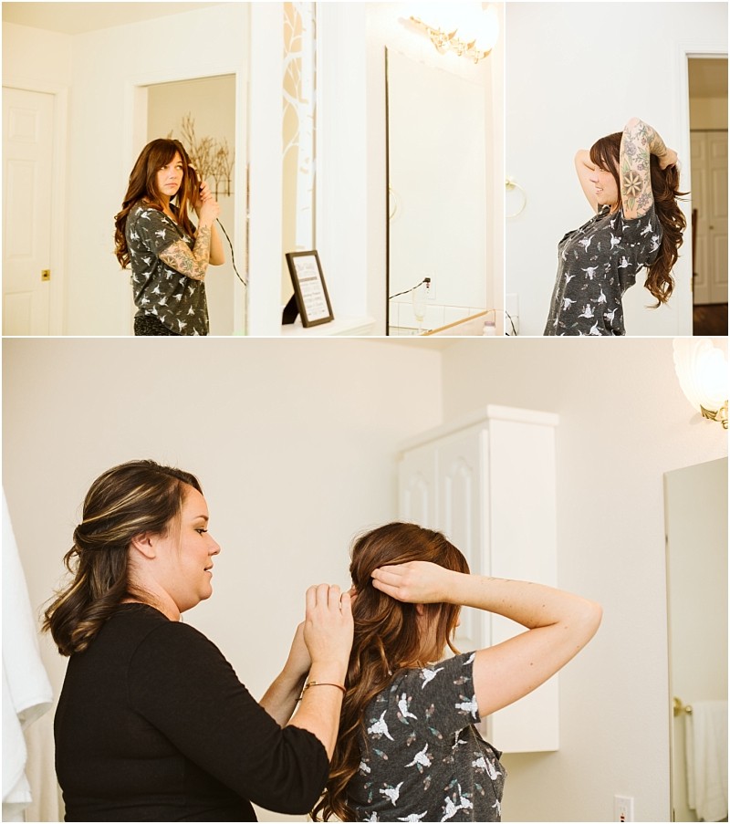 Premier snohomish & seattle wedding photographer | gsquared weddings photography a woman with long hair and tattoos styles her hair in front of a bathroom mirror preparing for her snohomish seattle wedding In another photo a second woman helps fix her hair from behind in the well lit white walled bathroom | serving snohomish seattle                   & beyond