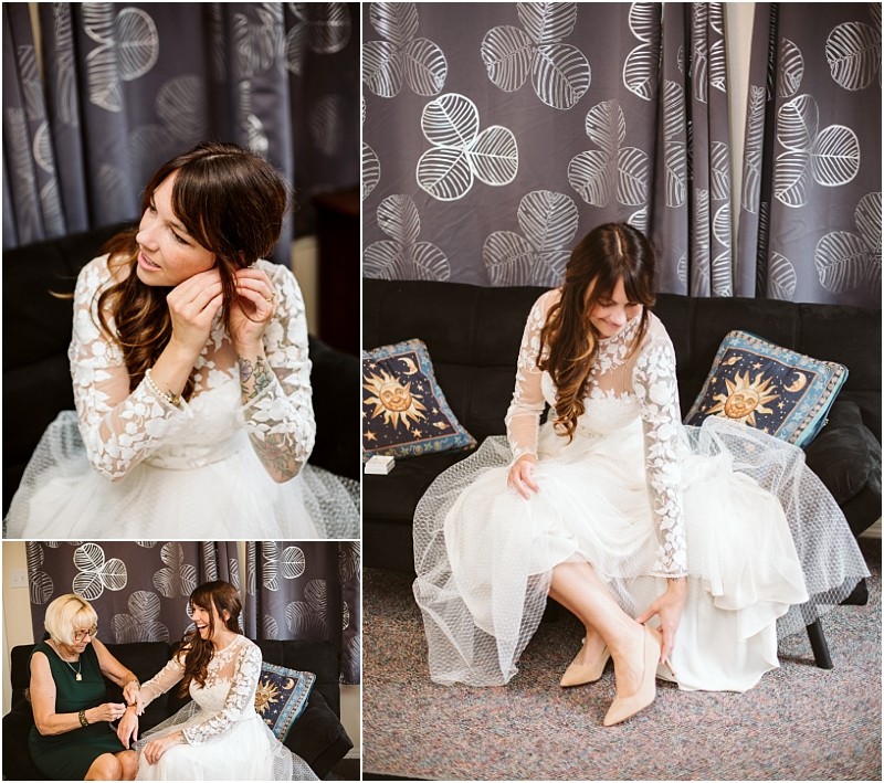 Premier snohomish & seattle wedding photographer | gsquared weddings photography a bride with long brown hair in a lace wedding dress sits on a sofa putting on earrings and shoes before her snohomish seattle wedding In another photo an older woman helps her Grey curtains and decorative pillows are in the background | serving snohomish seattle                   & beyond