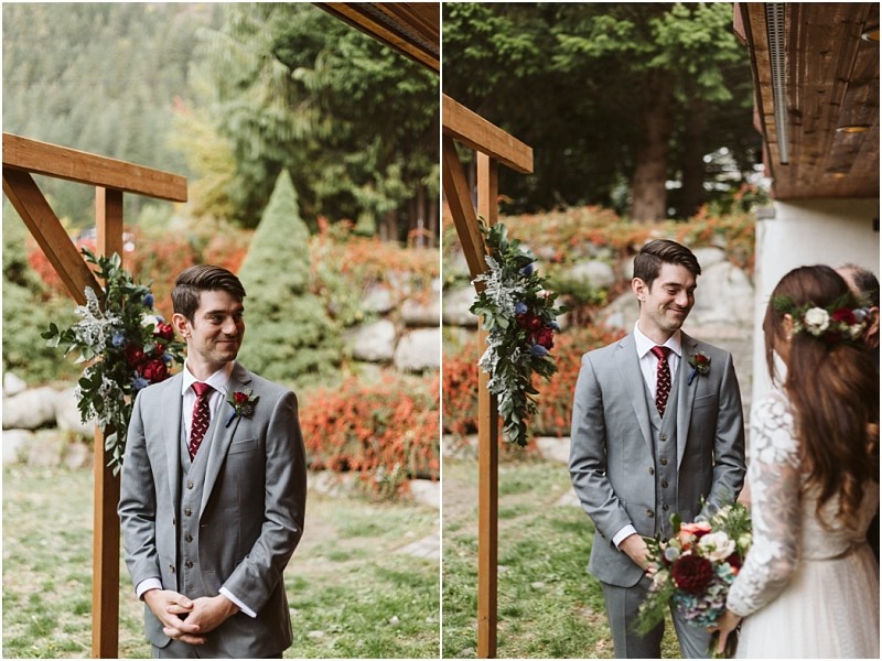 Premier snohomish & seattle wedding photographer | gsquared weddings photography a groom in a gray suit smiles as he sees his bride for the first time at their snohomish outdoor wedding ceremony surrounded by lush greenery and floral decorations capturing a special seattle wedding engagement moment | serving snohomish seattle                   & beyond