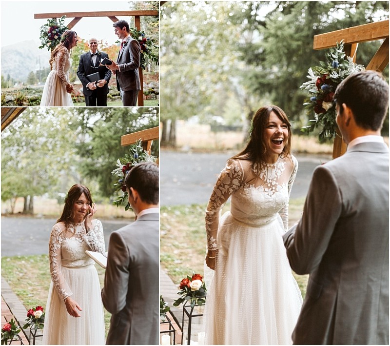 Premier snohomish & seattle wedding photographer | gsquared weddings photography a bride in a white long sleeved lace dress and a groom in a gray suit exchange vows outdoors at their snohomish wedding smiling and laughing joyfully under a wooden arch adorned with flowers | serving snohomish seattle                   & beyond