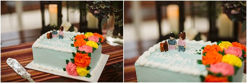 Premier snohomish & seattle wedding photographer | gsquared weddings photography a rectangular cake with blue icing white frosting borders and colorful buttercream flowers Two lego style figurines stand on topperfect for a snohomish or seattle wedding or engagement celebration A cake server rests nearby on a striped tablecloth | serving snohomish seattle                   & beyond
