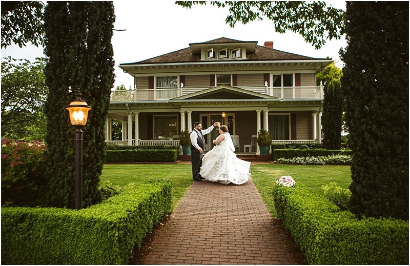 Premier snohomish & seattle wedding photographer | gsquared weddings photography a bride and groom dance on a brick walkway in front of an elegant snohomish house with a porch and manicured garden surrounded by greenery Perfect for a romantic seattle wedding or engagement a bouquet lies on the grass nearby | serving snohomish seattle                   & beyond