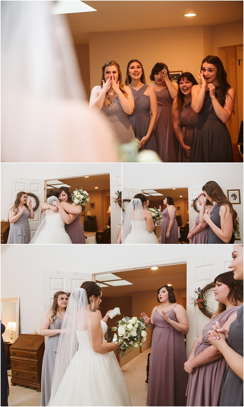 Snohomish & seattle wedding photographer | gsquared weddings photography a bride in a wedding dress shares an emotional moment with her bridesmaids during a marysville wedding as they react with surprise joy and tears upon seeing her gown for the first time inside a warmly lit room | wedding photo by gsquared weddings