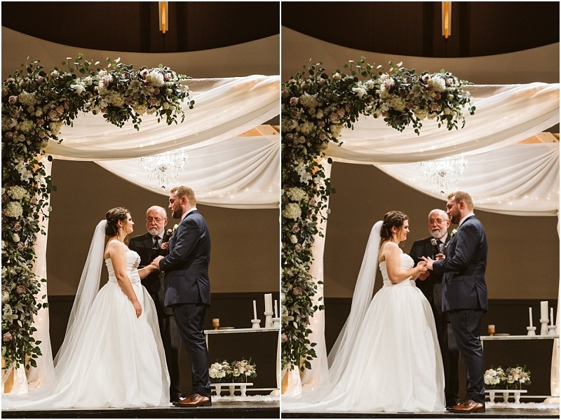 Snohomish & seattle wedding photographer | gsquared weddings photography a bride and groom stand under a floral wedding arch holding hands and exchanging rings during their marysville wedding ceremony with an officiant standing behind them | wedding photo by gsquared weddings