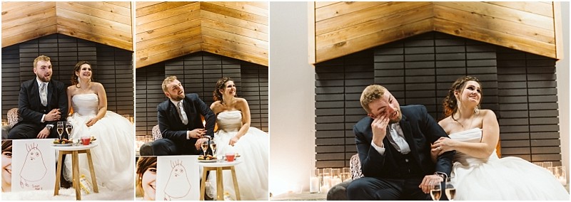Snohomish & seattle wedding photographer | gsquared weddings photography a bride and groom sit together in front of a fireplace at their marysville wedding laughing and wiping away tears with champagne glasses and a drawing on a small table beside them They appear joyful and emotional during the celebration | wedding photo by gsquared weddings