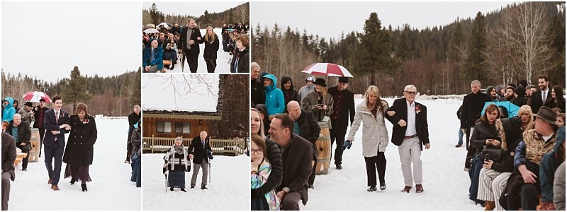 Snohomish & seattle wedding photographer | gsquared weddings photography a winter outdoor leavenworth wedding guests some with umbrellas walk down a snowy aisle surrounded by seated attendees and trees The mood is festive and joyful despite the cold weather | wedding photo by gsquared weddings