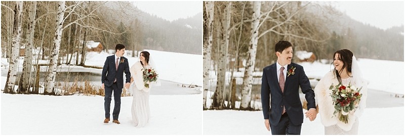 Snohomish & seattle wedding photographer | gsquared weddings photography a bride and groom walk hand in hand across a snowy landscape at their leavenworth wedding smiling at each other Bare trees and a pond are in the background with mountains partially visible in the distance | wedding photo by gsquared weddings