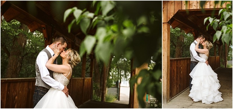 Snohomish & seattle wedding photographer | gsquared weddings photography a bride and groom embrace and share a kiss on a rustic wooden bridge surrounded by greenery during their intimate methow elopement with the bride in a white gown and the groom in a vest and jeans | wedding photo by gsquared weddings