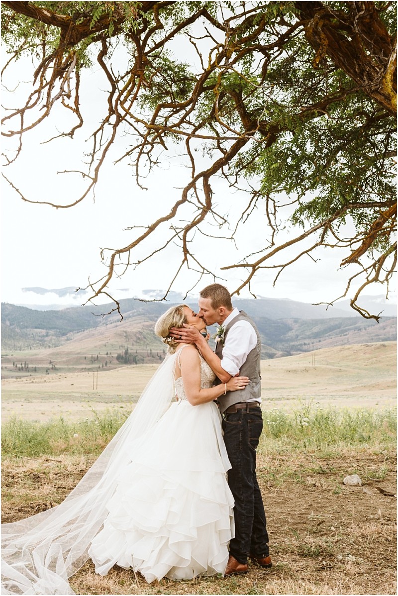 Snohomish & seattle wedding photographer | gsquared weddings photography a man and woman share a kiss under a tree during their intimate methow elopement | wedding photo by gsquared weddings