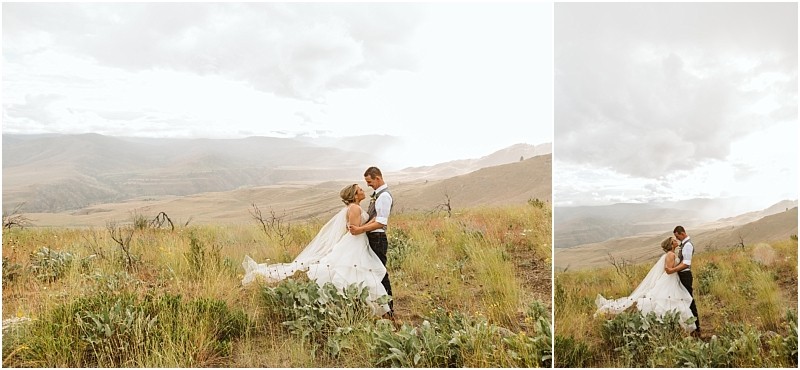 Snohomish & seattle wedding photographer | gsquared weddings photography a bride and groom stand in an open field surrounded by tall grass and wildflowers embracing during their methow elopement with mountains and a cloudy sky in the distance | wedding photo by gsquared weddings