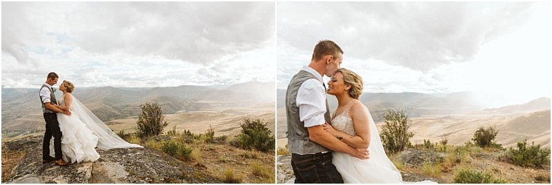 Snohomish & seattle wedding photographer | gsquared weddings photography a bride and groom stand together on a rocky hilltop with sweeping views of mountains and valleys under a cloudy sky sharing an intimate moment after their methow elopement | wedding photo by gsquared weddings