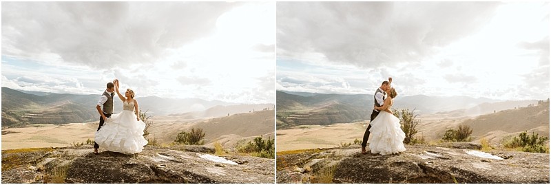 Snohomish & seattle wedding photographer | gsquared weddings photography a couple in wedding attire stands on a rocky hilltop with sweeping views of sunlit mountains and valleys embracing and smiling under a dramatic cloudy skya perfect methow elopement moment | wedding photo by gsquared weddings