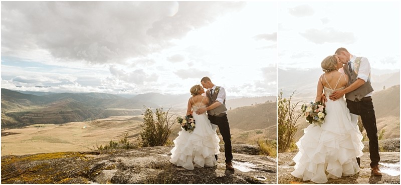 Snohomish & seattle wedding photographer | gsquared weddings photography a bride and groom embrace and kiss on a rocky overlook during their methow elopement with sunlit mountains and valleys behind them The bride holds a bouquet in her ruffled white gown the groom is in a vest and shirt | wedding photo by gsquared weddings