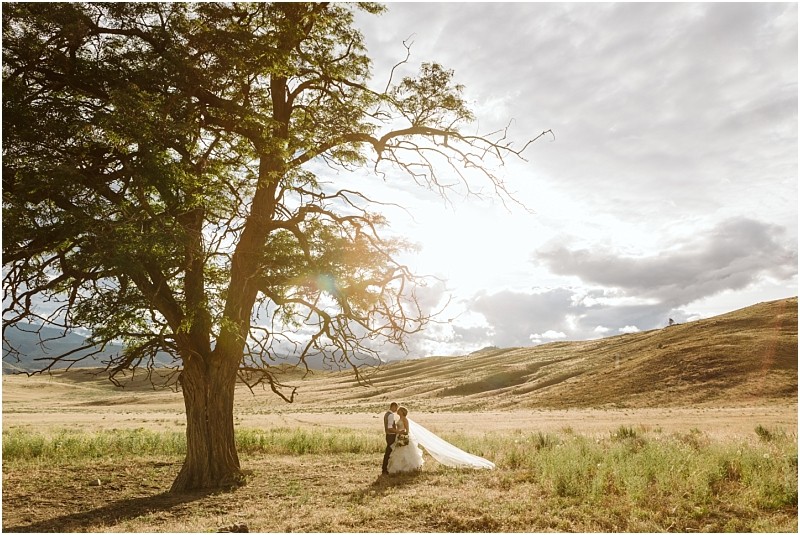 Snohomish & seattle wedding photographer | gsquared weddings photography a man and woman standing under a tree during their intimate methow elopement | wedding photo by gsquared weddings