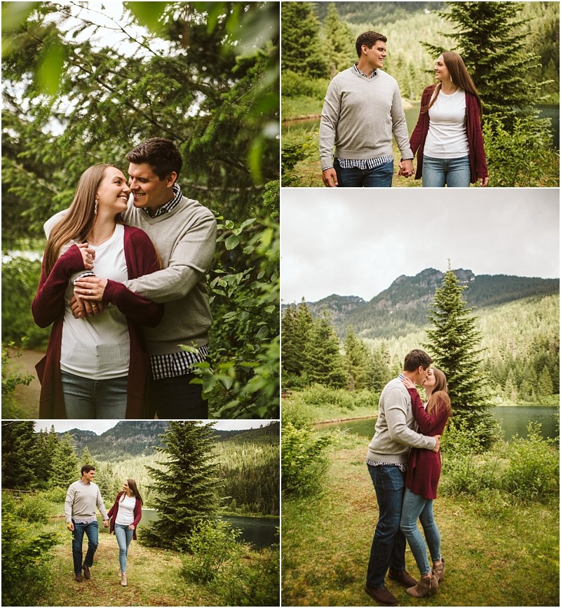 Snohomish & seattle wedding photographer | gsquared weddings photography a couple enjoys a walk in a lush green outdoor setting during their gold creek pond engagement They smile hold hands and embrace among trees with mountains and a lake in the background | wedding photo by gsquared weddings