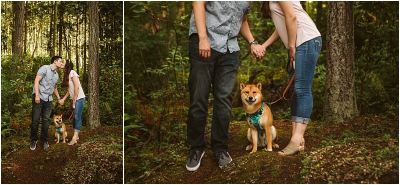 Snohomish & seattle wedding photographer | gsquared weddings photography a couple stands in a forest during their deception pass engagement session holding hands and leaning in for a kiss while their shiba inu wearing a green harness sits between them on the mossy ground | wedding photo by gsquared weddings