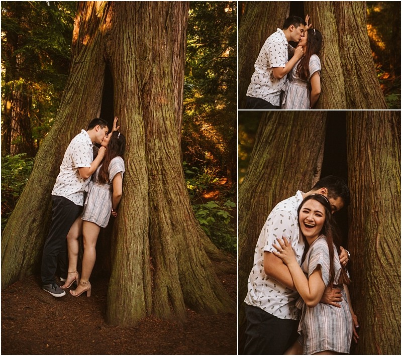 Snohomish & seattle wedding photographer | gsquared weddings photography a young couple poses playfully and intimately by a large tree in the forest laughing hugging and sharing a kiss amid the lush greenery during their deception pass engagement session in june 2020 | wedding photo by gsquared weddings