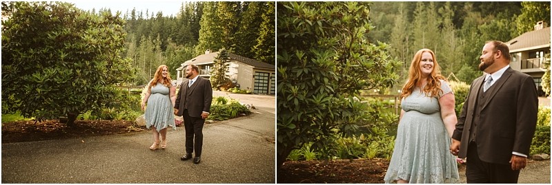 Snohomish & seattle wedding photographer | gsquared weddings photography a couple dressed in formal attire holds hands and smiles at each other while walking outdoors on a paved path surrounded by greenery and trees celebrating their gray bridge engagement with a house visible in the background | wedding photo by gsquared weddings