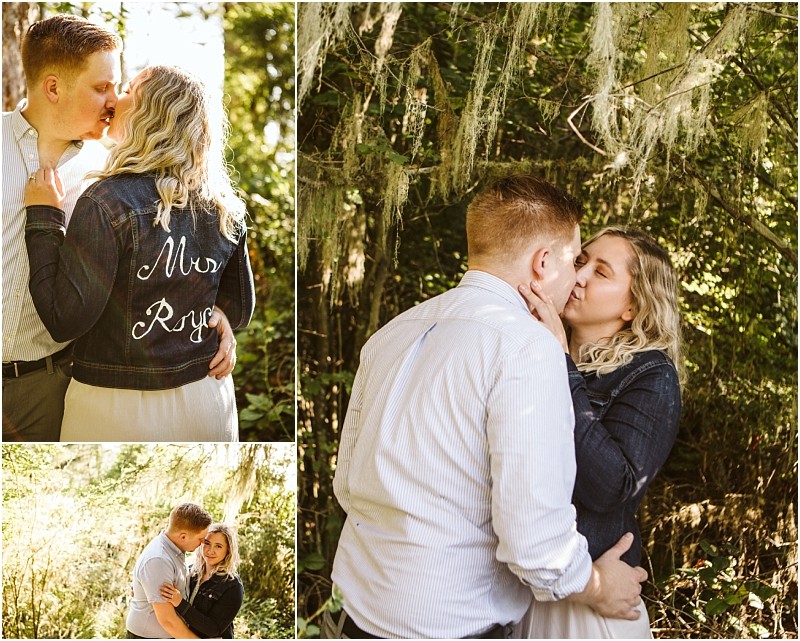 Snohomish & seattle wedding photographer | gsquared weddings photography a couple embraces and kisses in a sunlit wooded area at deception pass whidbey island The woman wears a denim jacket with mrs Ryon on the back The man has short blonde hair and wears a light shirtthey appear affectionate and happy | wedding photo by gsquared weddings