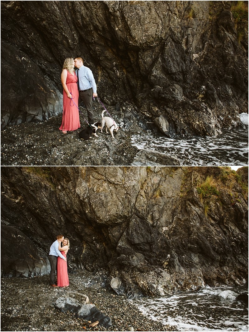 Snohomish & seattle wedding photographer | gsquared weddings photography a couple shares an intimate moment with their dogs on the rocky shore at deception pass whidbey island Waves lap gently as the woman in a pink dress and the man in a shirt and tie celebrate their engagement by the waters edge | wedding photo by gsquared weddings