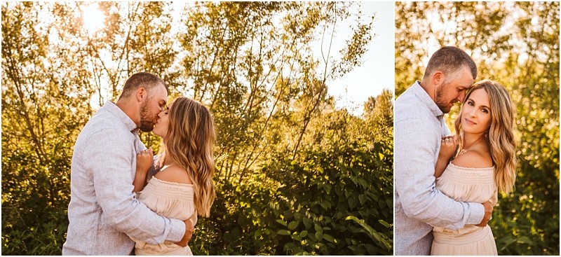 Snohomish & seattle wedding photographer | gsquared weddings photography a couple stands outdoors at pemberton farm in snohomish embracing closely amid sunlit greenery The man gently kisses and rests his forehead against the woman as she looks at the camera both dressed in light colored clothing for their engagement | wedding photo by gsquared weddings