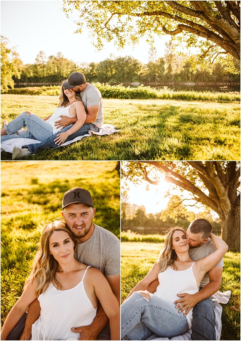Snohomish & seattle wedding photographer | gsquared weddings photography a couple sits on grass under a large tree in the sunshine at pemberton farm snohomish The man hugs and kisses the pregnant woman as they relax together and smile at the camera in a beautiful outdoor park setting | wedding photo by gsquared weddings