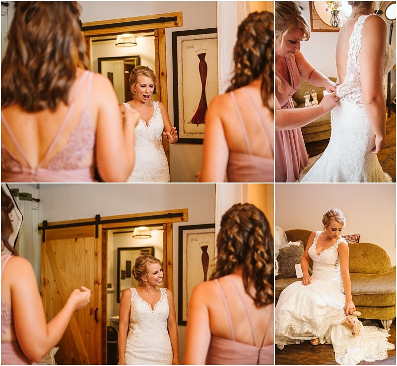 Snohomish & seattle wedding photographer | gsquared weddings photography a bride in a lace wedding dress is helped by bridesmaids in mauve dresses as she gets ready for a summer barn at holly farm wedding smiling and adjusting her gown inside a cozy room with wood accents and framed dress artwork on the walls | wedding photo by gsquared weddings
