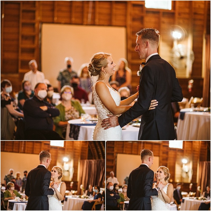 A bride and groom share their first dance at a wedding reception in a rustic snohomish hall smiling at each other as guests watch from decorated tables in the warmly lit background Snohomish wedding photography