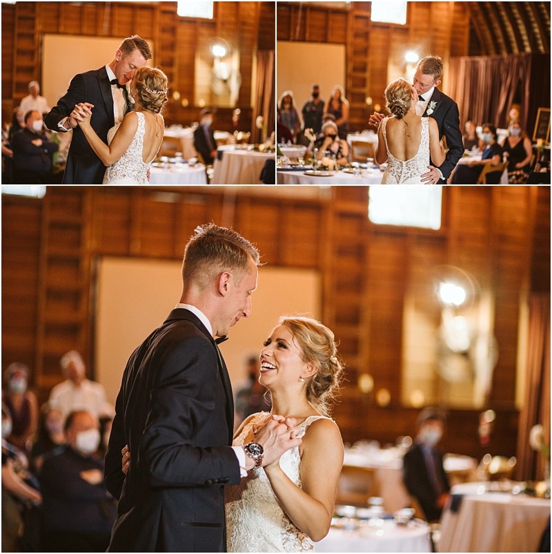 A bride and groom share their first dance at a wedding reception in a warmly lit wooden snohomish venue Guests watch from their tables as the happy couple smiles holding each other close on the dance floor Snohomish wedding photography