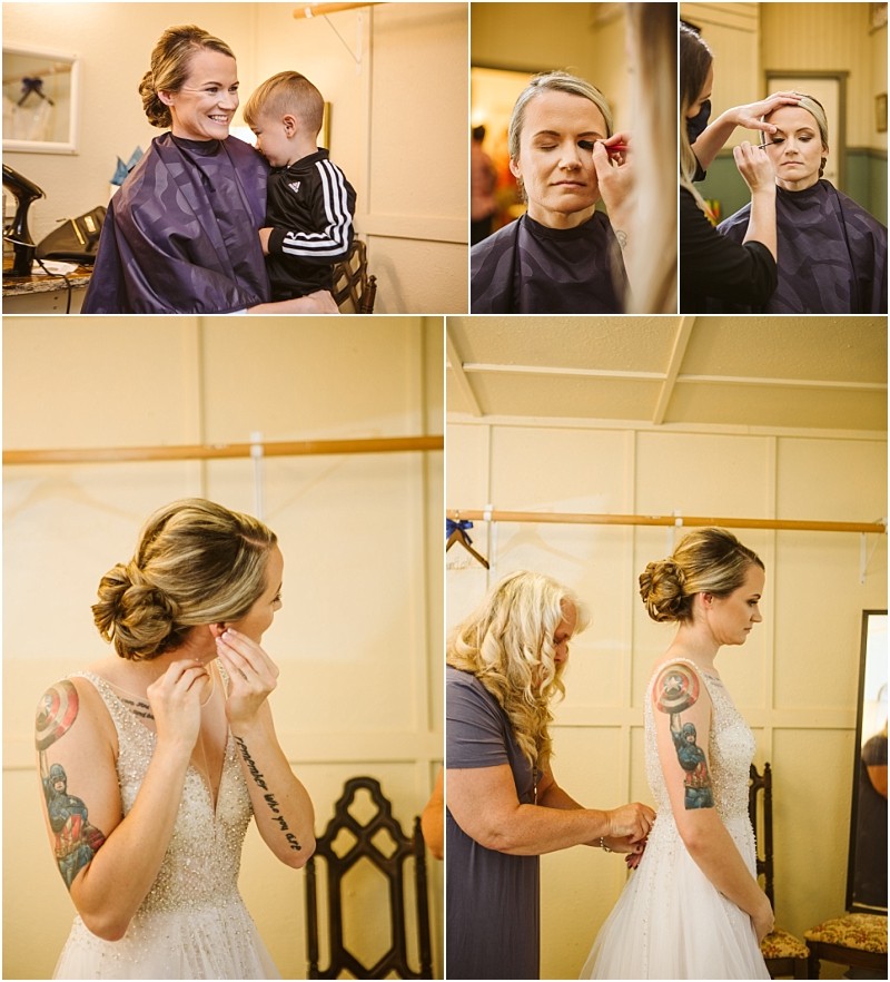 A snohomish bride gets ready for her wedding hugging a child having her makeup done putting on earrings and her dress being fastened by a woman The bride has tattoos on her arm and wears a beaded white gown Snohomish wedding photography