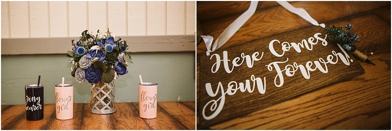 Three personalized tumblers and a blue flower bouquet rest on a wooden table in snohomish left A wooden sign with white script reads here comes your forever with a ribbon attached right Snohomish wedding photography