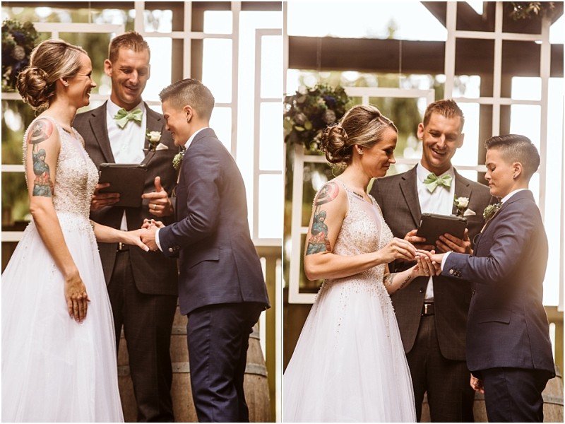 Two people exchange rings at an outdoor snohomish wedding ceremony smiling as an officiant stands behind them The bride wears a white dress the other person wears a navy suit The scene is joyful and intimate Snohomish wedding photography