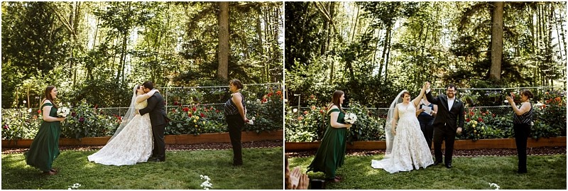 A bride and groom share a kiss during their outdoor snohomish forest wedding ceremony then raise their joined hands in celebration while two attendants stand nearby Bright sunlight shines through the trees Snohomish wedding photography